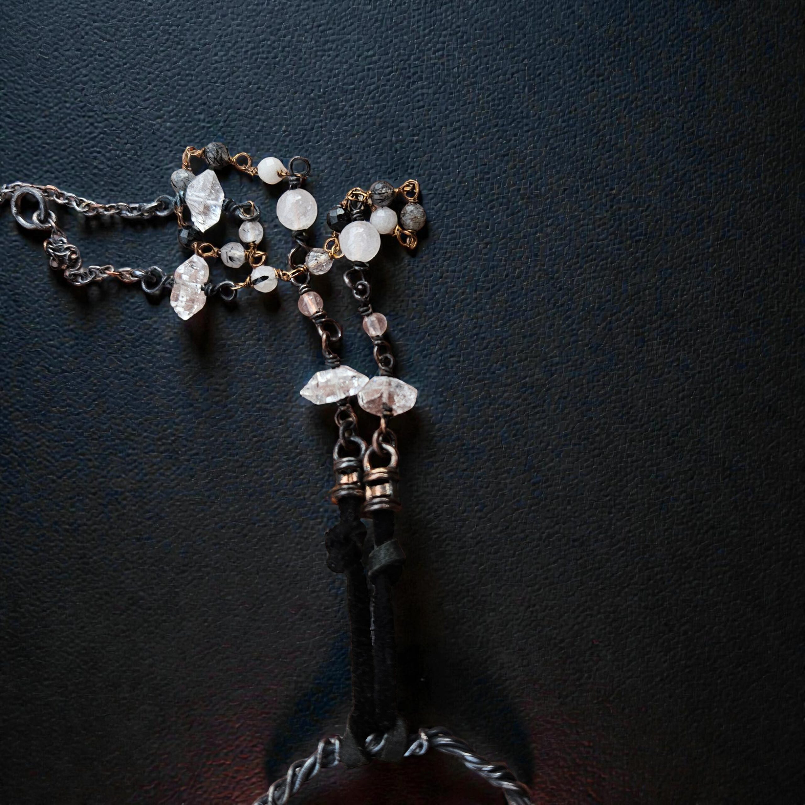 A detailed view of the 18-inch necklace chain, showing the mix of black leather, pure copper, and hand-beaded Herkimer diamond and Rutile accents.
