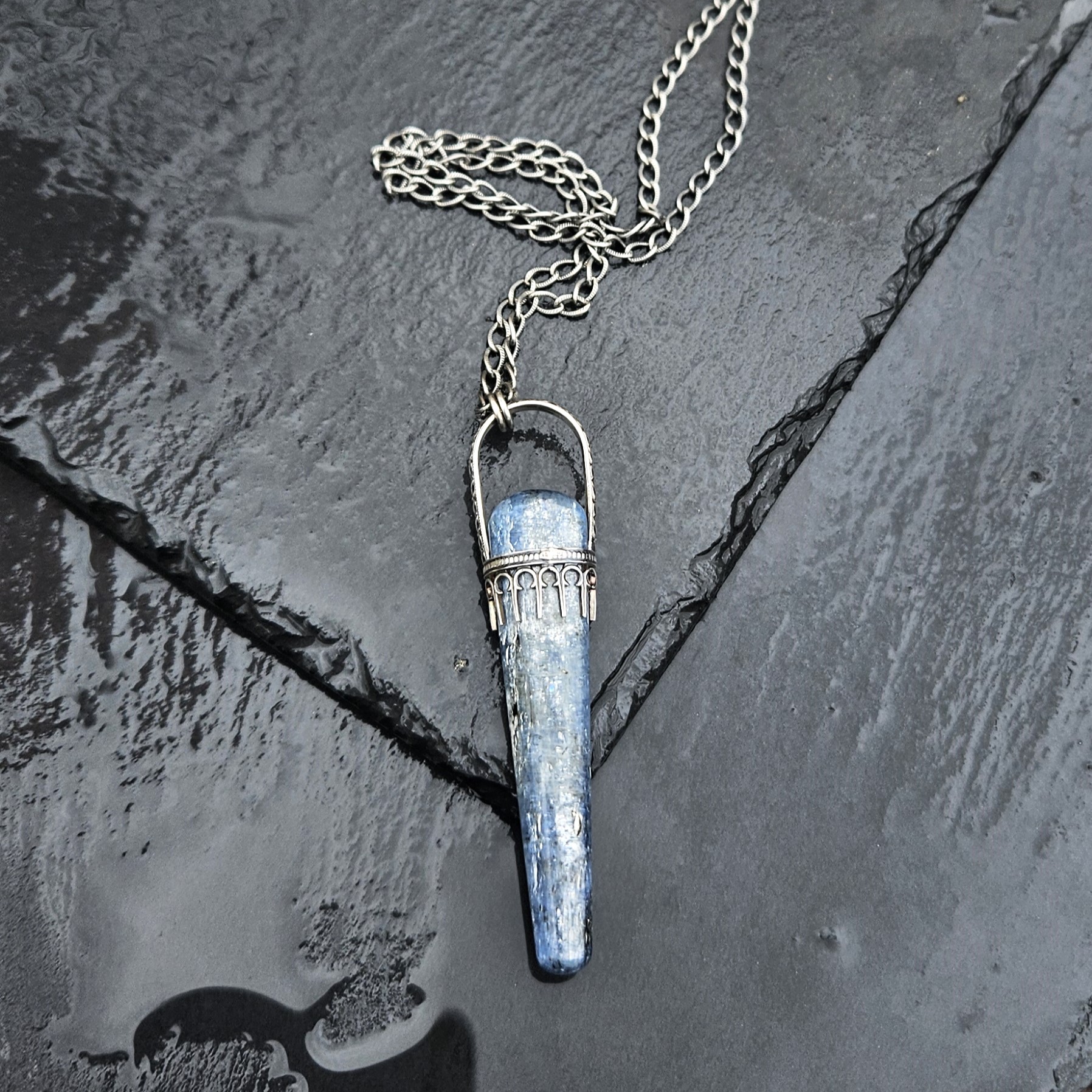 Blue Kyanite sceptor set in sterling silver photographed on a black slate stone background.