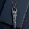 Blue Kyanite sceptor necklace set in sterling silver photographed on a black slate background.