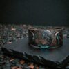 Macro shot of the Blue Moon cuff (large size) on a dark background. Showing the gnarled detailing and the midnight blue patina.