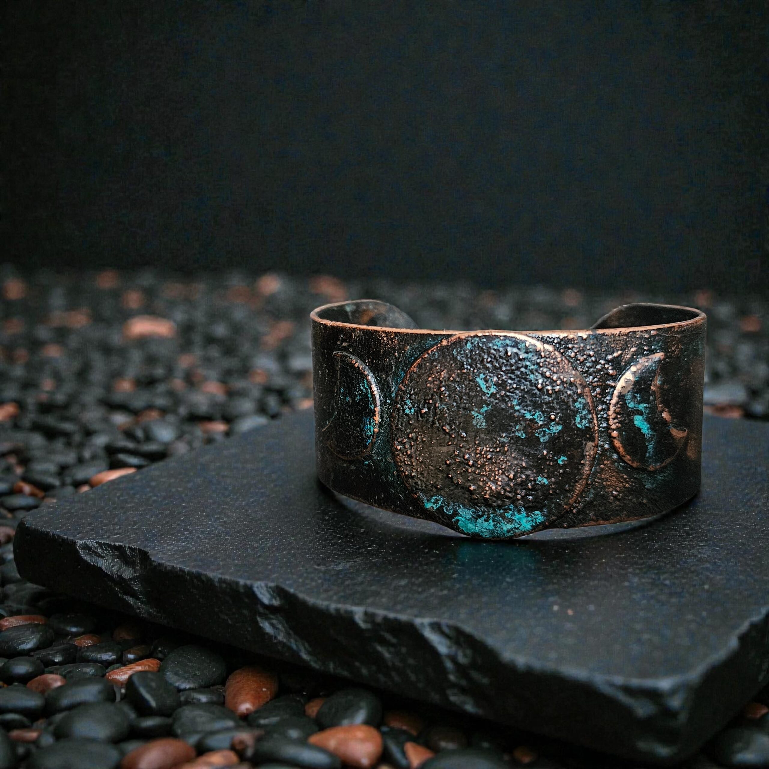 Macro shot of the Blue Moon cuff (large size) on a dark background. Showing the gnarled detailing and the midnight blue patina.