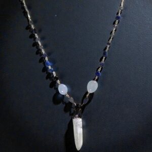 Lemurian quartz point with hand linked beaded chain shown on a black background