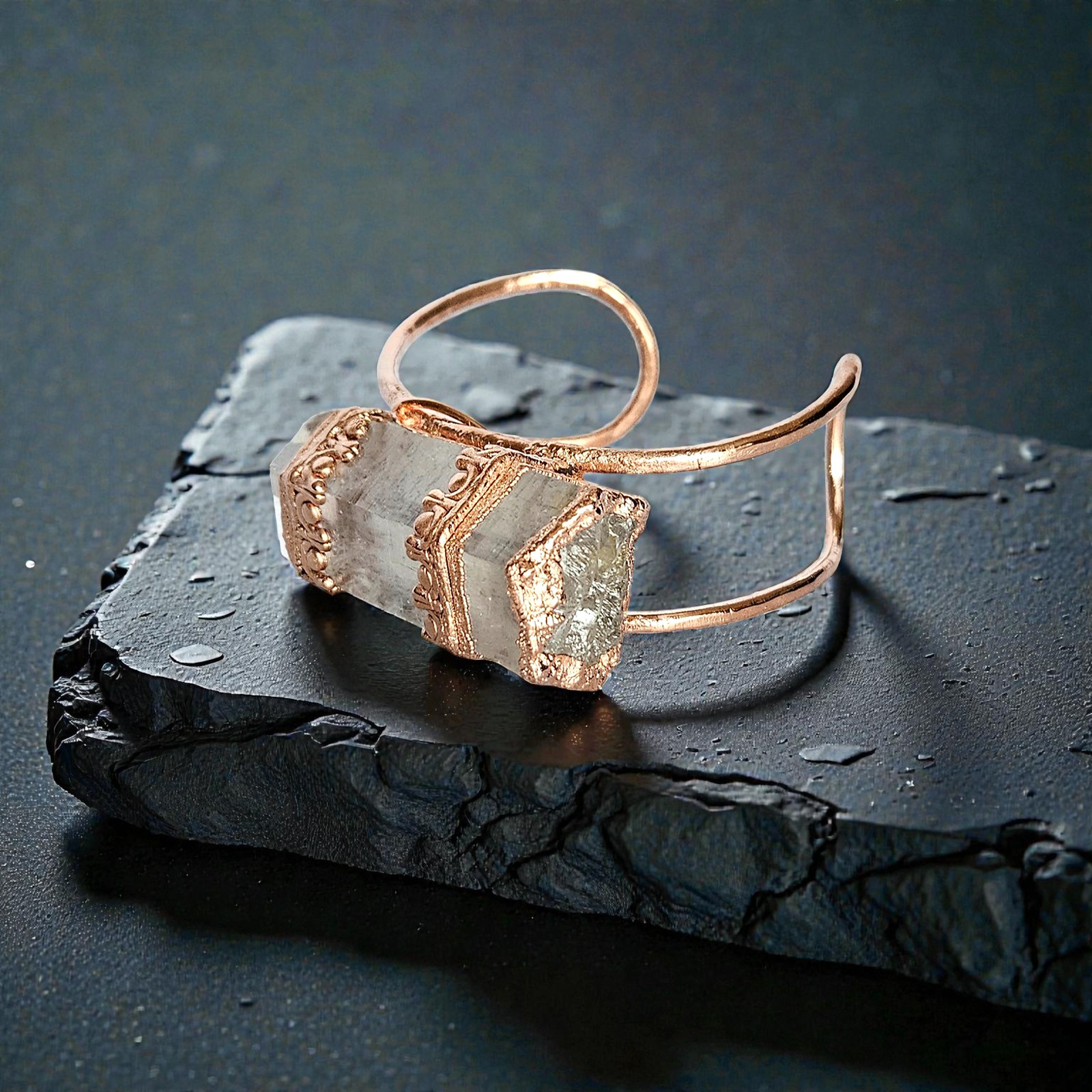 Moody product shot of The Archeron Cuff, a massive clear quartz crystal set in ornate copper on a dark, wet slate background.