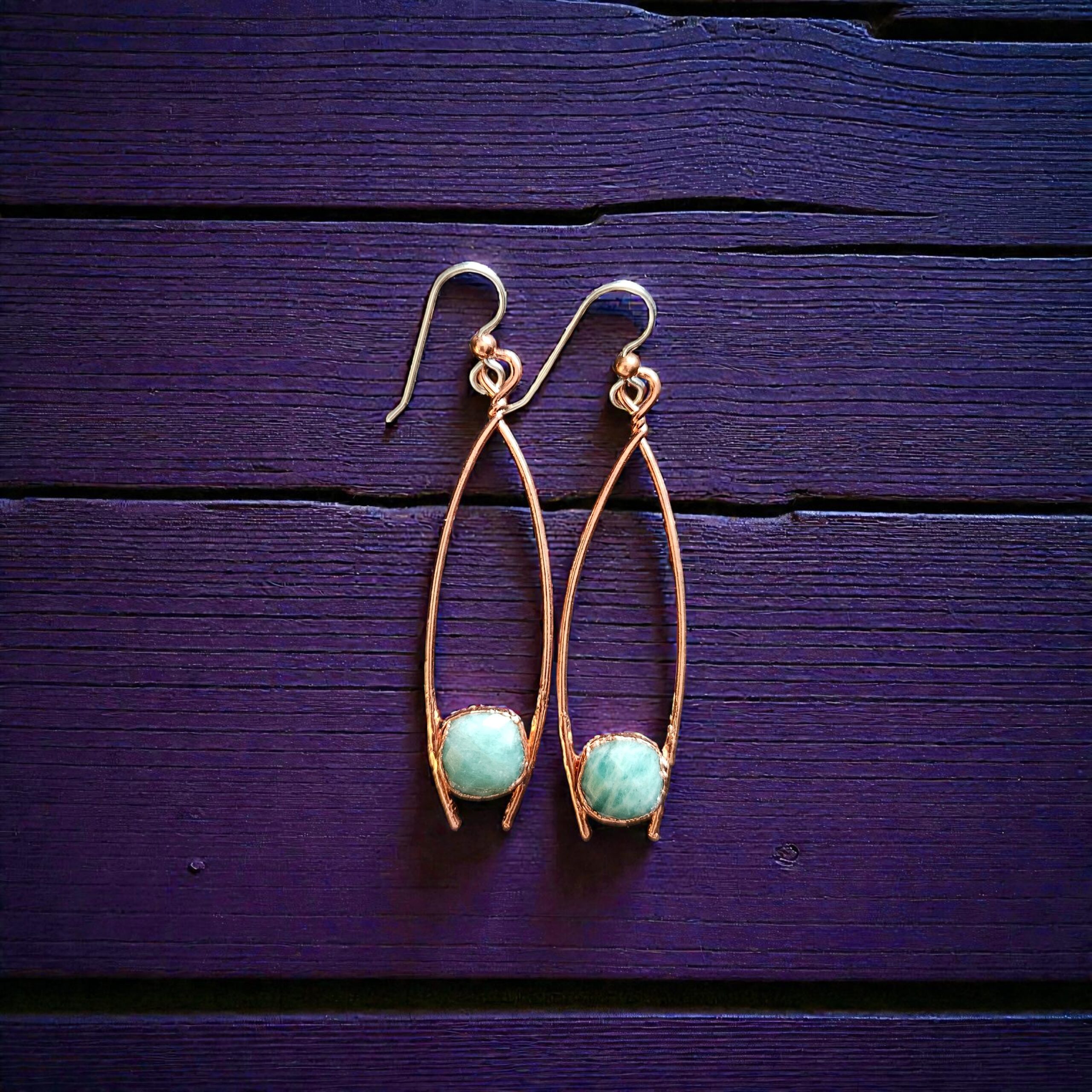 Close-up of the raw aquamarine stones, showing the intricate, dark-patina copper armor and the sterling silver earwire accents.