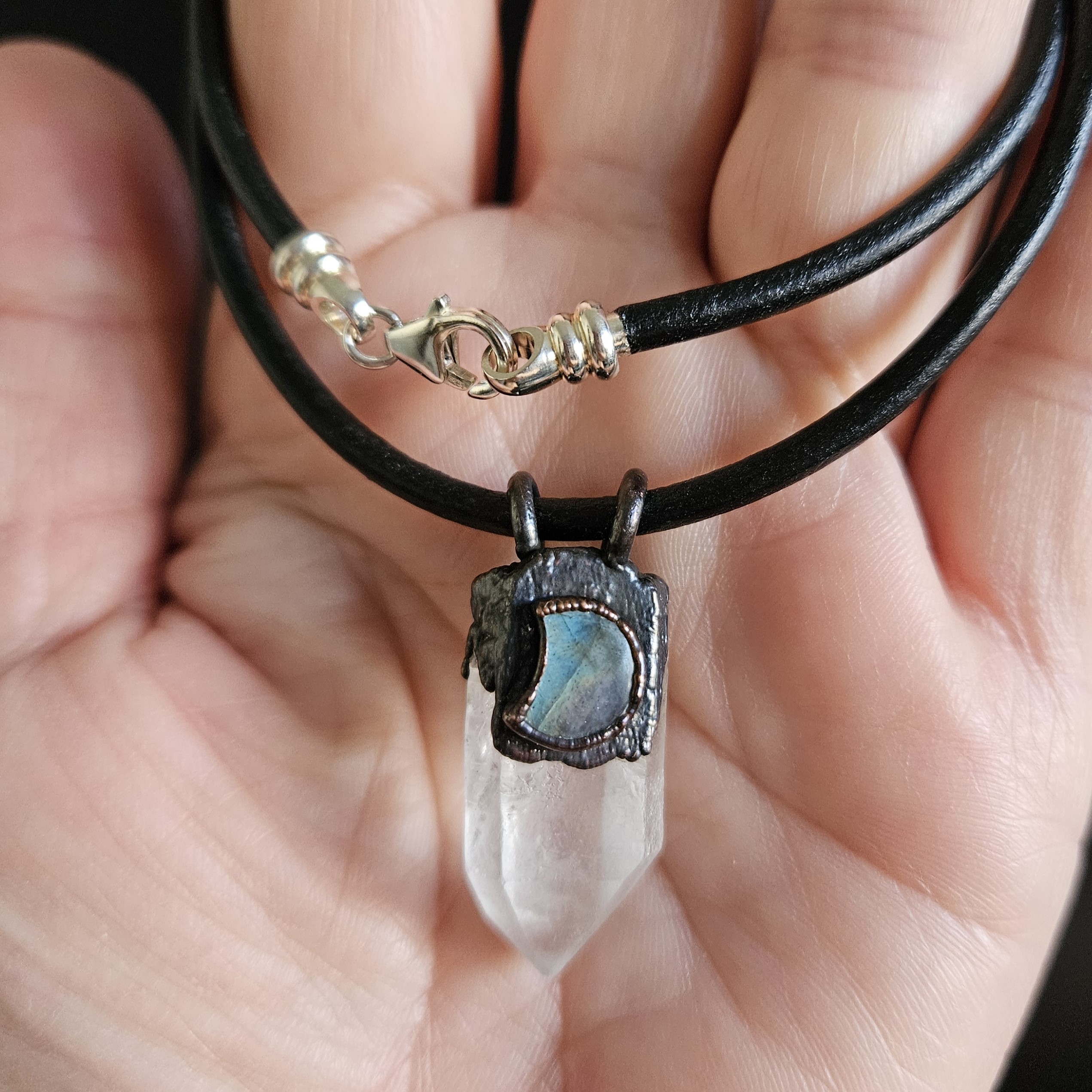 Close up of Labradorite and Quartz amulet shown in hand