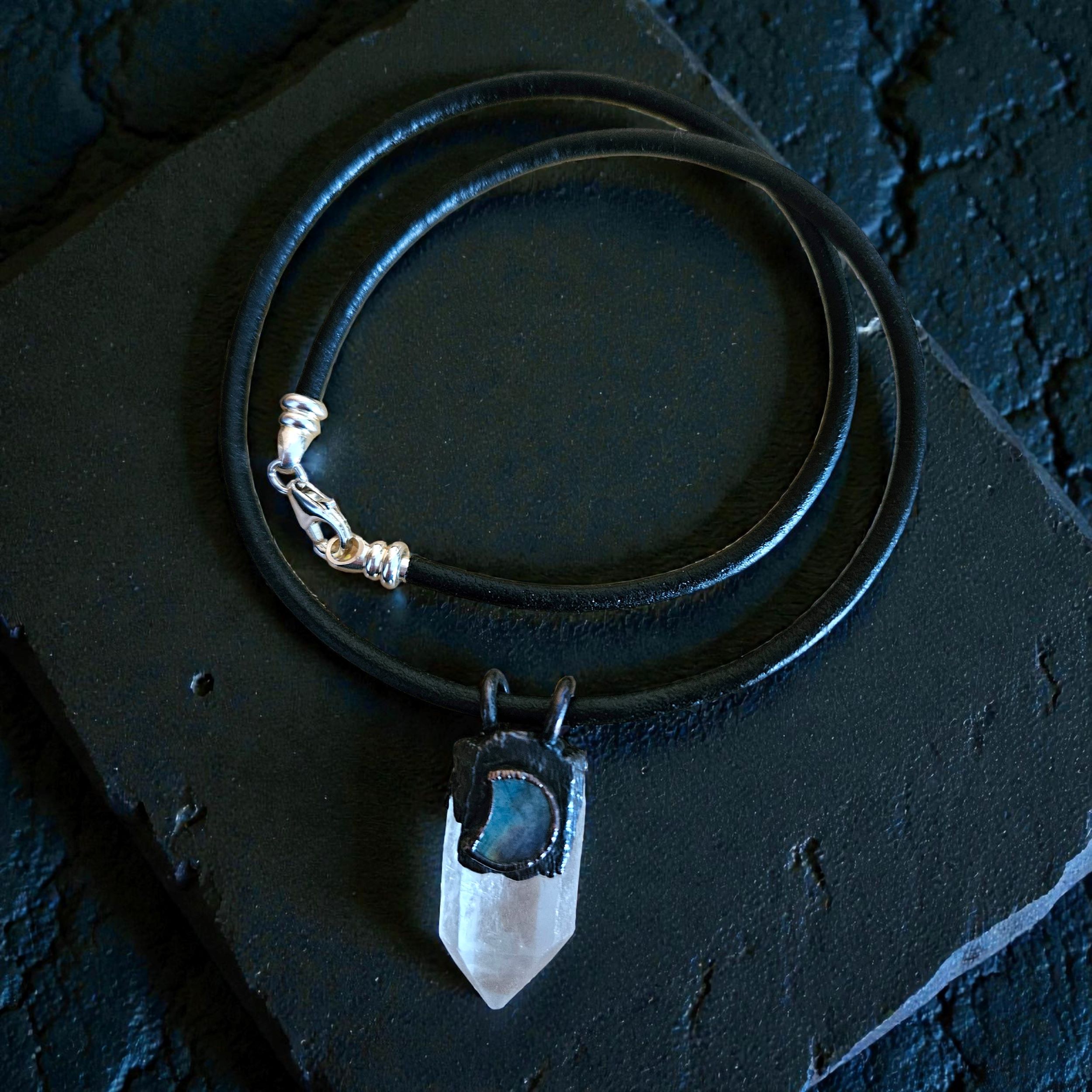 A flat lay closeup of the Navigator Amulet showcasing the amulet and the sterling silver closure.