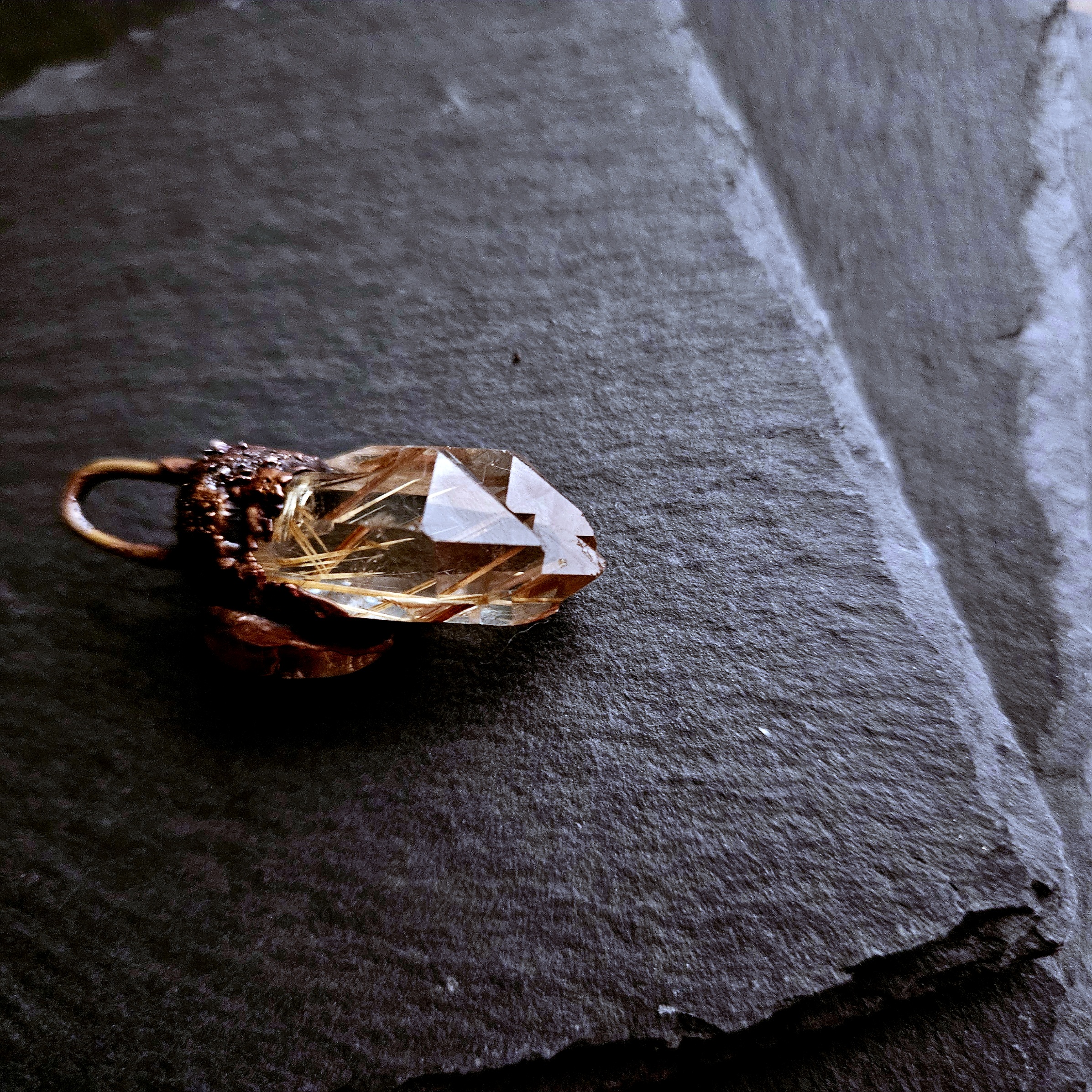 Golden Rutile Quartz point on it's side showing the twin points