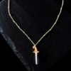 Close-up of a clear quartz crystal point set into a textured copper witch hat pendant. The image highlights the transparency of the crystal and the delicate rose gold beaded chain.