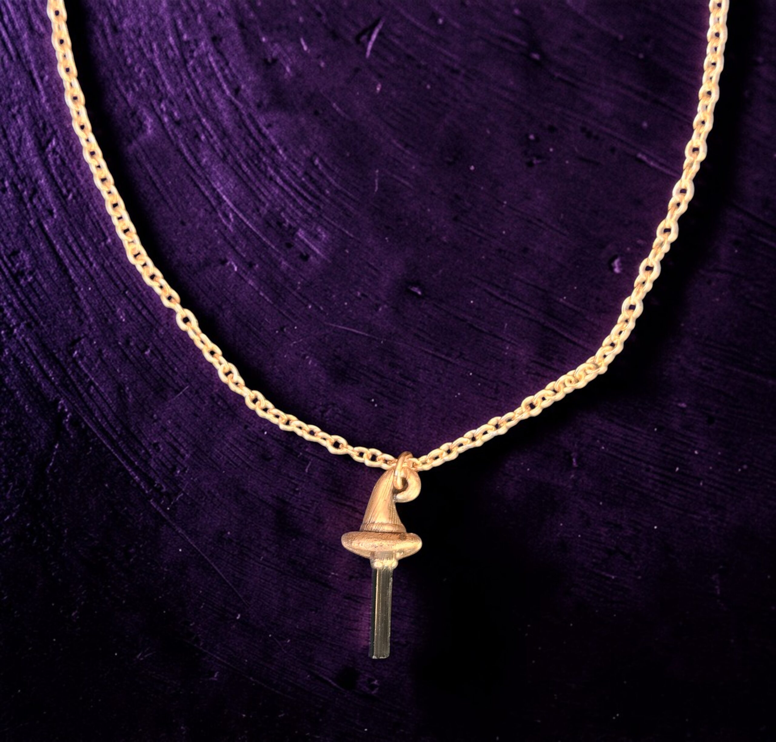 Macro photograph of a black tourmaline crystal set into a textured copper witch hat pendant. Detailed view showing the natural vertical striations of the protective stone and the rugged metal finish.