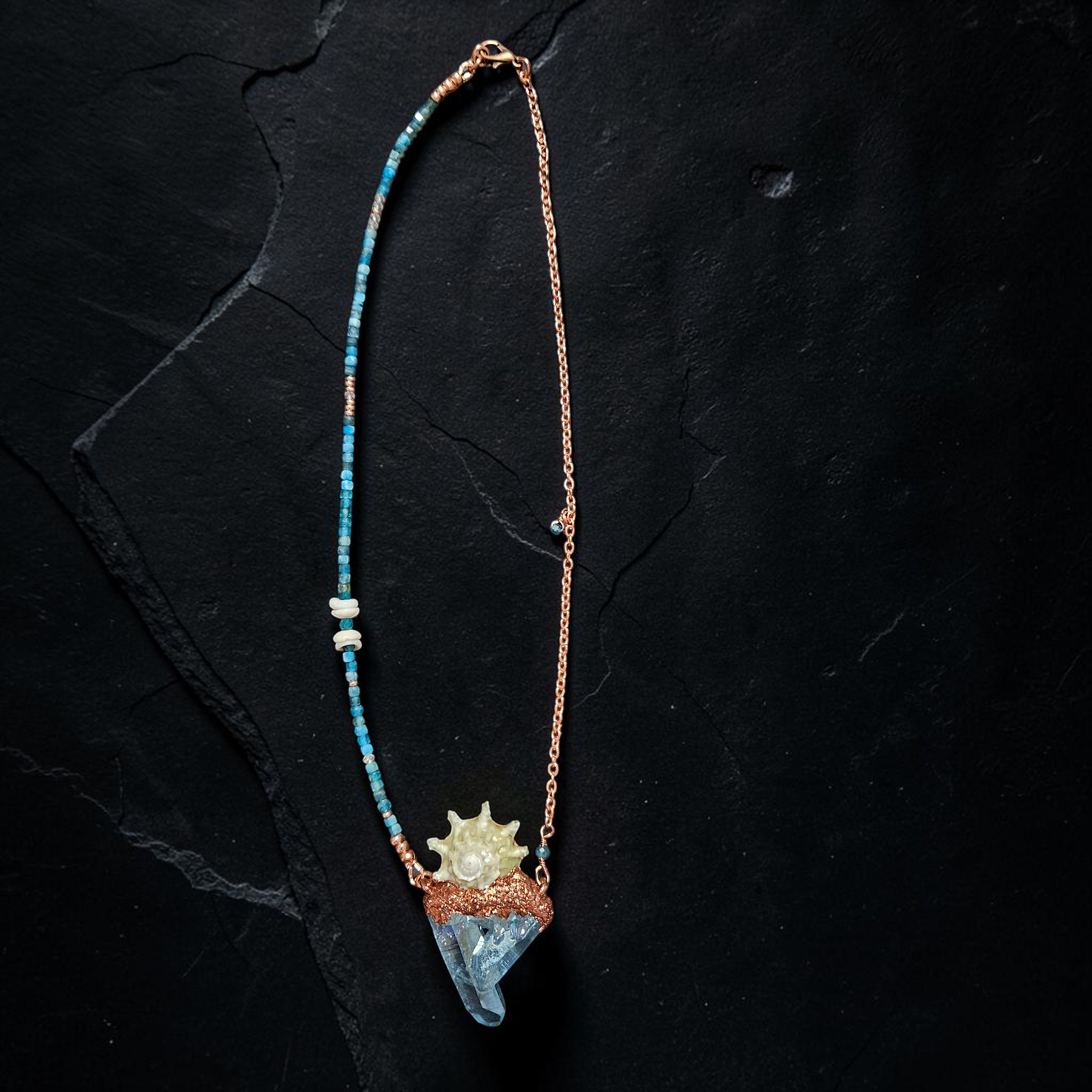A focused product photo highlighting the entire 17-inch necklace layout, showing the clean transition from the heavily detailed gemstone and shell strand on one side to the sleek copper link chain on the other.