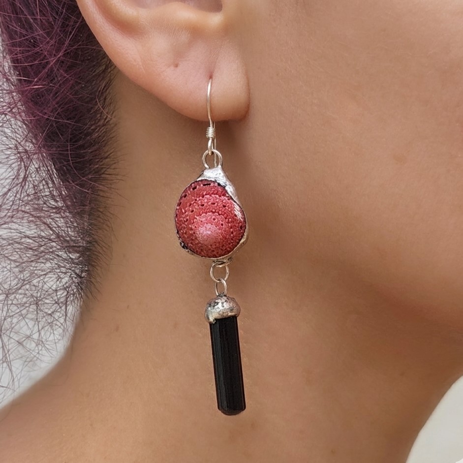 A close-up profile view of a model wearing one of the strawberry shell and black tourmaline earrings, demonstrating how the 2-inch length drapes elegantly below the earlobe with sterling silver earwires.