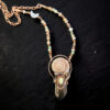 A hand-grown copper electroformed pendant featuring a long smoky quartz crystal point crowned with a spiral sundial shell and a milky opal cabochon. The piece is suspended from a 17-inch mixed accent bead and copper link chain.