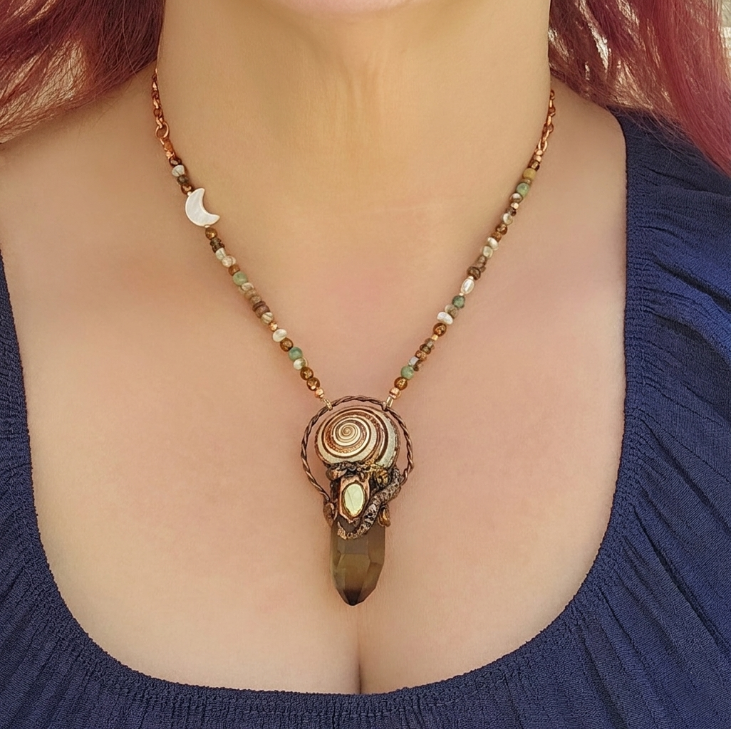 A modeled shot demonstrating the 2.5-inch drape of the smoky quartz talisman against a navy blue neckline, showing how the asymmetrical crescent moon sits elegantly on the left collarbone.
