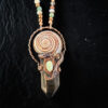 Extreme close-up highlighting the rich, organic textures of the copper electroformed setting, the perfect geometry of the sundial shell, and a smooth, milky pale-yellow opal centerpiece nestled at the junction.