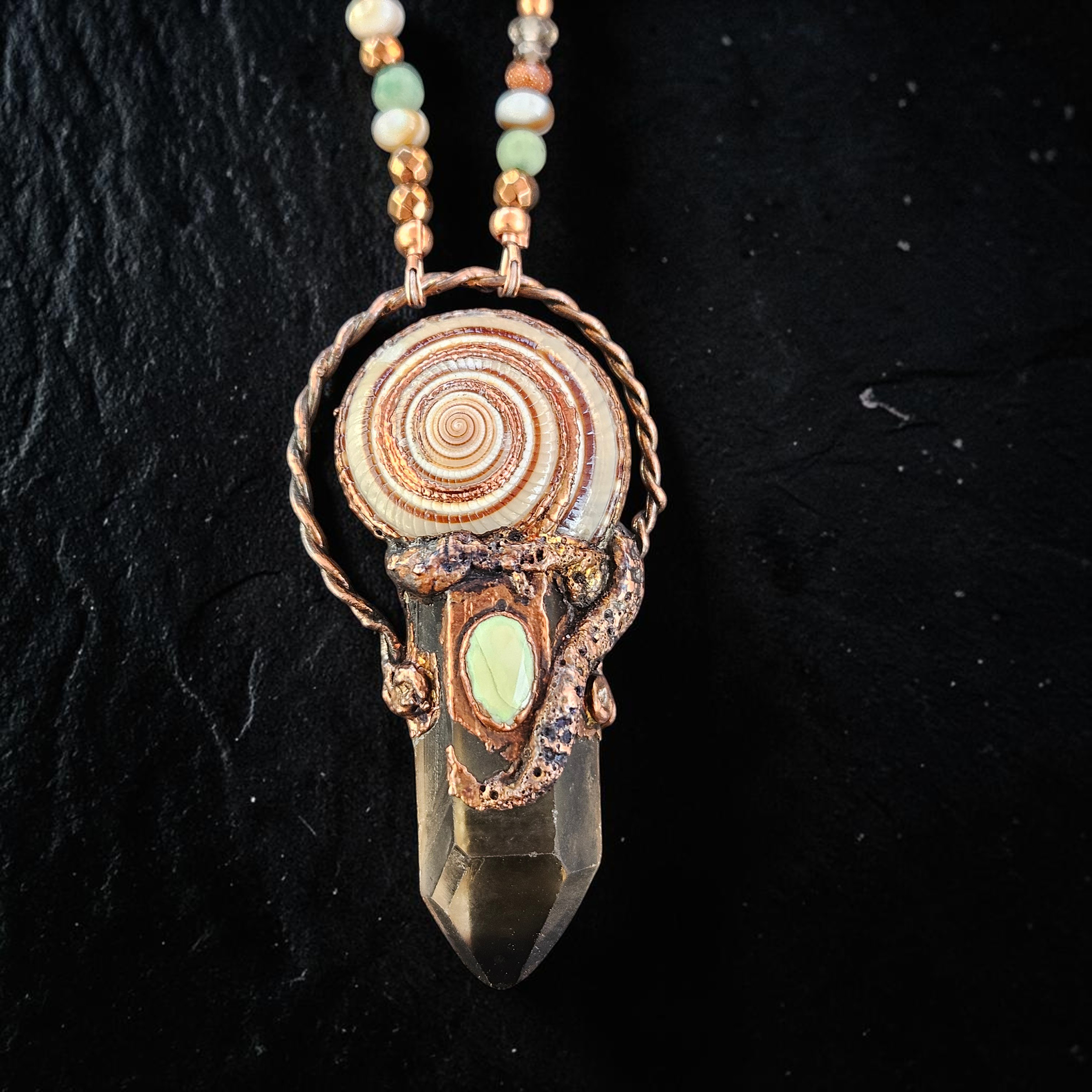 Extreme close-up highlighting the rich, organic textures of the copper electroformed setting, the perfect geometry of the sundial shell, and a smooth, milky pale-yellow opal centerpiece nestled at the junction.