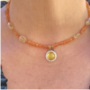 Model wearing the 16-inch golden amber amulet, showing the collar-length drop of the carnelian strand and round silver pendant on the chest.