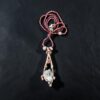 Vertical view of a 24-inch micro-faceted garnet bead strand coiled above a dual-branch copper electroformed pendant with raw clear quartz, dark pearls, and blue sapphire accents.