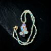 Hand-knotted blue and green gemstone bead necklace coiled on black slate around an electroformed copper cluster pendant featuring aqua aura quartz, lapis lazuli, and blue kyanite, with a 14k gold-filled lobster clasp.